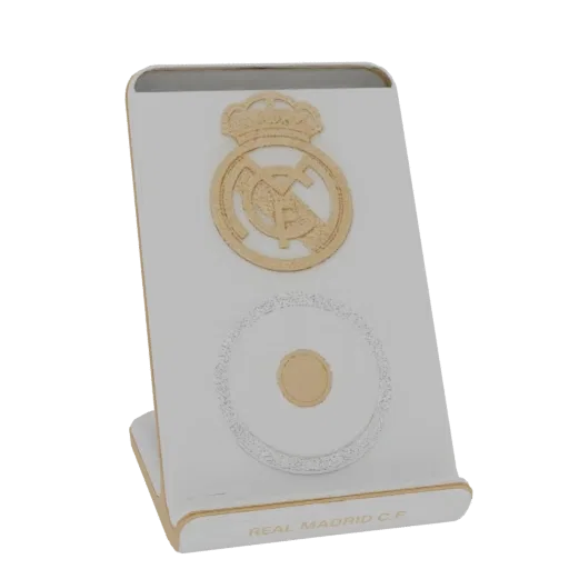 3D model render of a white desktop stand featuring the gold Real Madrid C.F. crest and a silver circular emblem, with 'REAL M