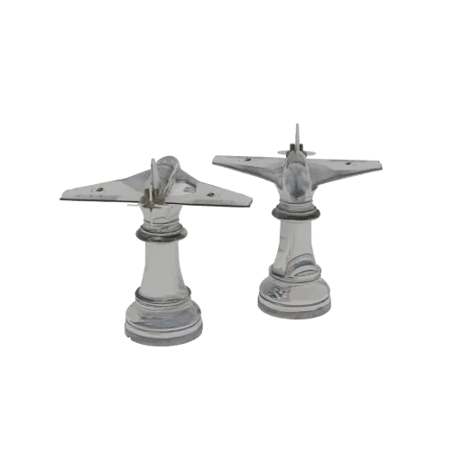 Two chrome airplane chess pieces, one with wider wings on the left and another with a more compact design on the right, displ