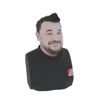 Una renderización 3D de un busto estilizado de un hombre sonriente con pelo negro pinchudo y camiseta negra, presentado sobre