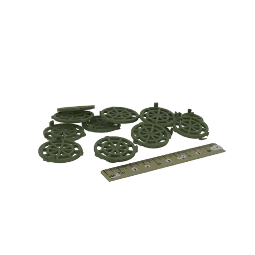 A pile of 10 green circular spacers with a spoke design, next to a ruler for scale.