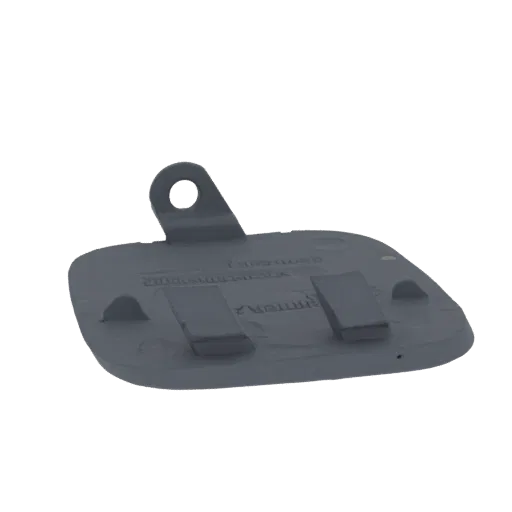 A 3D model of a dark gray car bumper tow hook cover, viewed from a slight angle, showing its mounting tab and clip details.