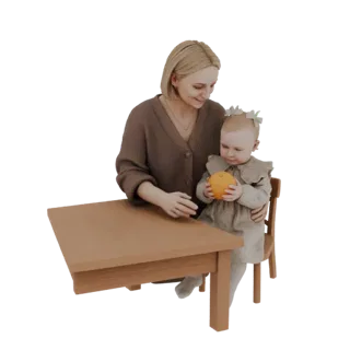 Modelo 3D de una madre sosteniendo a un bebé, ambos sentados en una mesa de madera, con el bebé sosteniendo una naranja.