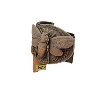3D model of an ornate belt buckle featuring a detailed bee design surrounded by decorative elements, with a yellow label read