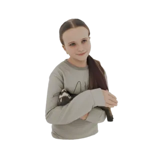 3D model of a young girl with brown hair, wearing a gray sweatshirt, smiling and holding a ferret in her arms.