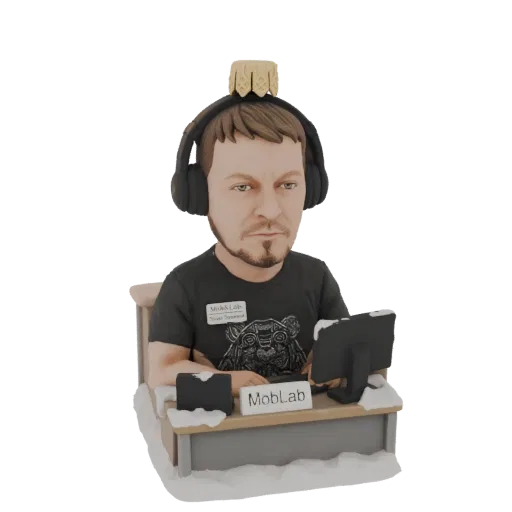 3D model of a gamer wearing headphones, sitting at a desk with a computer, with snow on the ground.