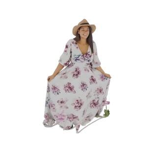 3D model of a smiling woman wearing a white floral maxi dress with purple flowers and a straw sun hat, standing with her dres