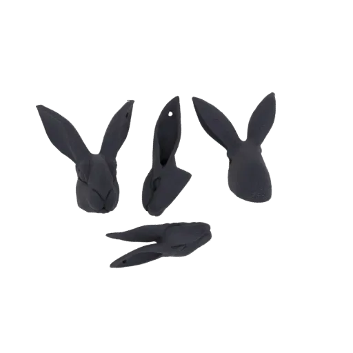 A collection of four stylized dark gray rabbit heads, viewed from different angles, against a white background.