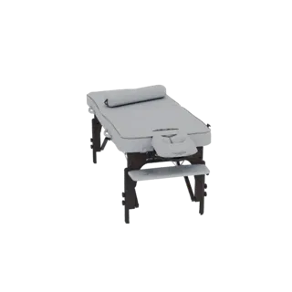 A 3D render of a light gray massage table with a dark wooden frame and a face cradle, set against a black background.