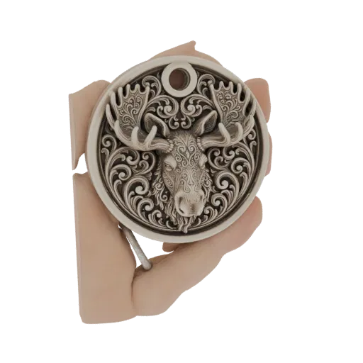 Un modello 3D di un ciondolo circolare con una testa di alce dettagliata con volute intarsiate e corna, tenuto da due mani.