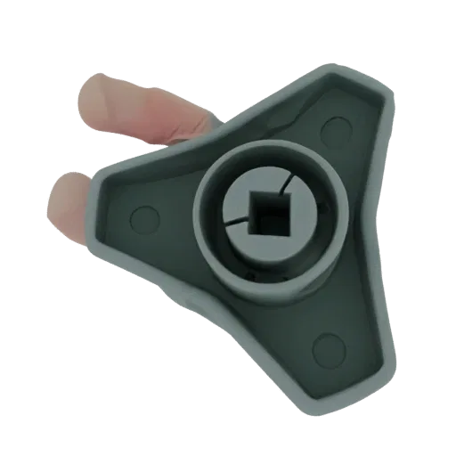 A hand holding a grey triangular grip knob with a square central opening.