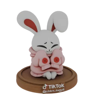 Modèle 3D d'un mignon lapin blanc portant un sweat rose, assis sur une base en bois avec un logo TikTok.