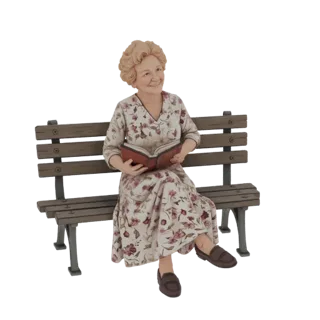 Modello 3D di un'anziana con capelli biondi, che indossa un vestito floreale, mentre legge un libro seduta su una panchina de