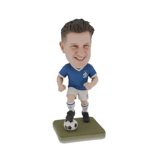 3D model of a football player bobblehead in a blue jersey and white shorts, with a soccer ball at his feet, standing on a gre
