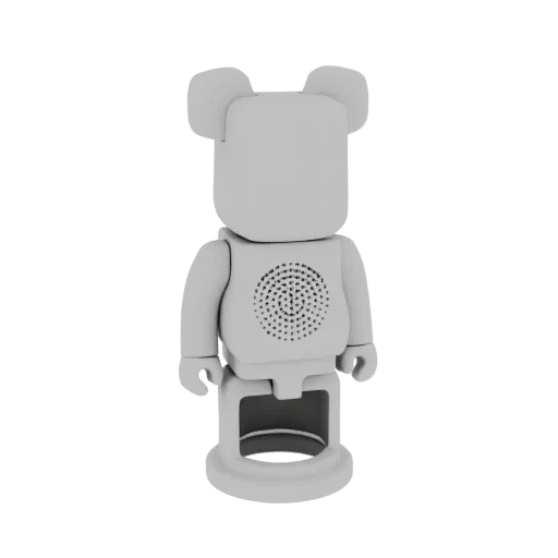 3D model render of a gray Bearbrick-style toy with a circular speaker grille on its chest, standing on a base.