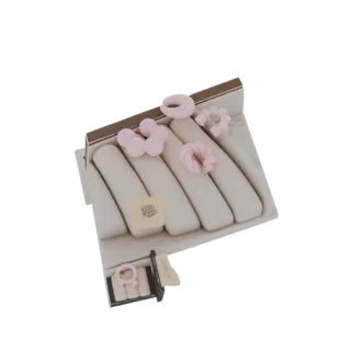 Modelo 3D de uma bandeja expositora de joias com contas e anéis pastel e uma pequena peça floral de acento.