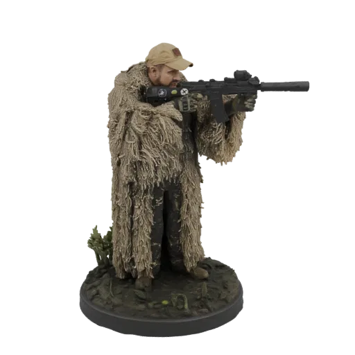 3D model of a sniper wearing a detailed ghillie suit and holding a rifle, posed on a diorama base.