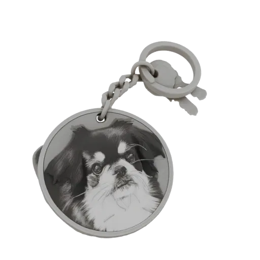3D model of a circular keychain featuring a black and white portrait of a Japanese Chin dog, with a chain and key charm.