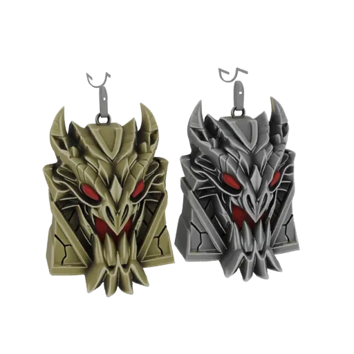 Dos modelos 3D de colgantes de cabeza de dragón, uno dorado y otro plateado, con ojos rojos, presentados como llaveros sobre