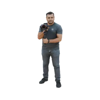 3D model of a man in a grey t-shirt and jeans, holding a black camera gimbal stabilizer with both hands.