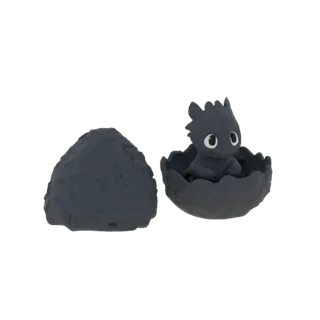 3D model of a cute baby Night Fury dragon with large eyes, emerging from a cracked eggshell, with a separate piece of the egg