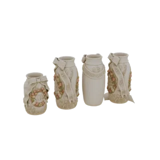 A set of four cream-colored decorative vases with intricate floral ribbon designs, displayed together.