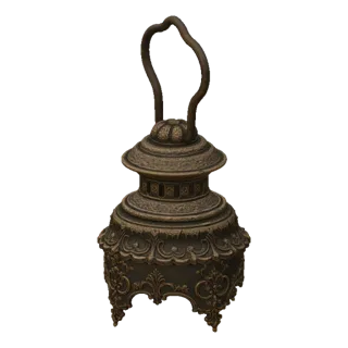 A detailed 3D model of an ornate bronze Victorian lantern with intricate scrollwork and a curved handle, set against a white
