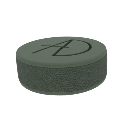 A 3D render of a stylized puck with a textured grip and a prominent 'AD' logo debossed on its top surface.