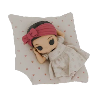 3D model of a cute baby doll with a pink headband and floral dress, sleeping peacefully on a pillow with a heart pattern.