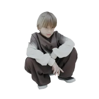 3D model of a young boy with blonde hair, wearing a brown and cream sweatshirt and brown pants, crouching and looking down.
