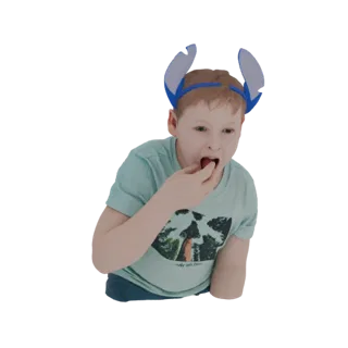 A young boy wearing a blue headband with large, light blue and dark blue Stitch-inspired ears, eating a piece of food.