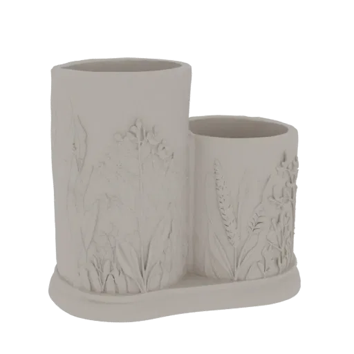 A 3D render of a light-colored, double-compartment pen holder with embossed floral and botanical designs.