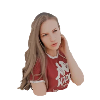 3D model of a young woman with long blonde hair, wearing a red Kappa t-shirt, looking towards the viewer with her hand near h